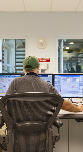 A technician oversees the control center for a public water utility company.