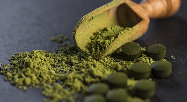 Organic spirulina powder and tablets shot on a slate