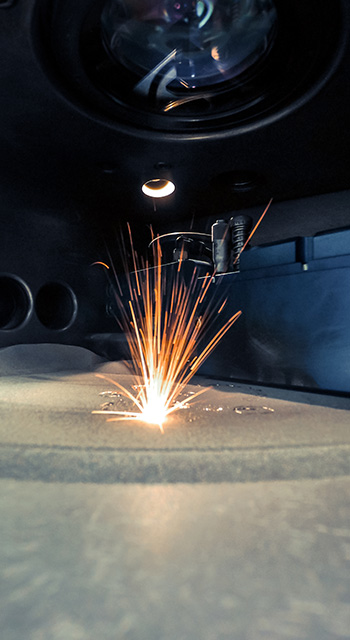 3D printer printing metal. Laser sintering machine for metal. Metal is sintered under the action of laser into shape. DMLS, SLM, SLS. Modern additive technologies 4.0 industrial revolution. Sparks