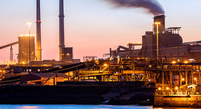 A large steelworks on the river illuminated at night in industrial district near Amsterdam, Netherlands, Benelux, Europe. Smoking chimneys, tanks and other installations are visible. Numerous colorful lights of a steel plant are reflected in the river. Long exposure with tripod, 50 megapixel image taken with the new Canon EOS 5Ds.
