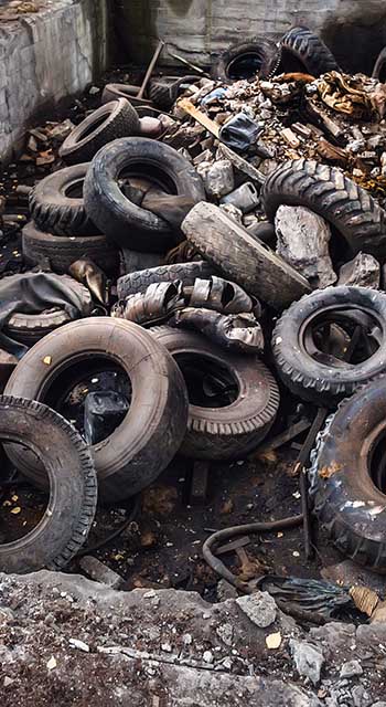 Heap of old car junk tires, used truck rubbish wheels, industrial garbage in abandoned factory, toned