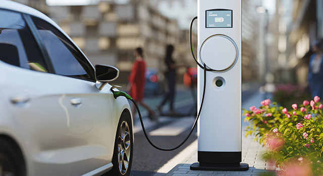 An electric vehicle at a charging station in the city. All items in the scene are 3D, charging station and concept cars are not based on any real ones.