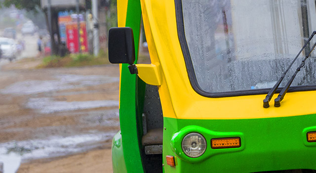 Green and yellow eco-friendly electronic tuk tuk vehicle car rickshaw in Luang Prabang Laos in Asia.